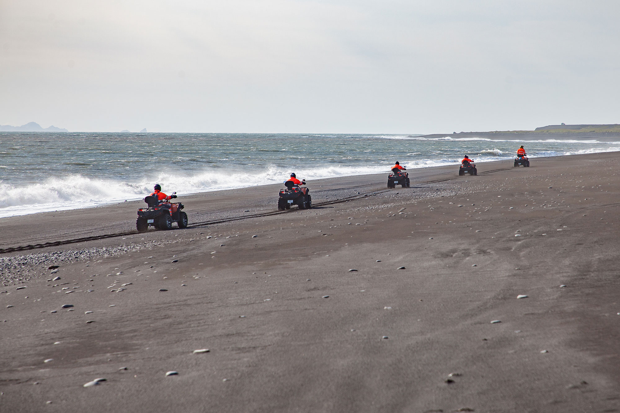 Hópur fjórhjóla að keyra meðfram strandlínunni